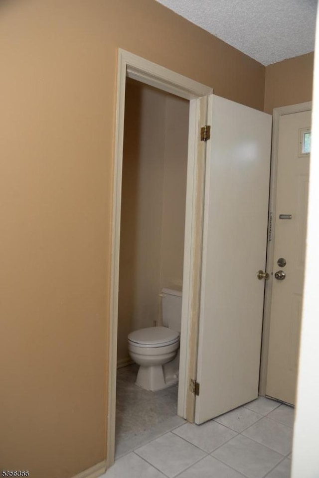 bathroom featuring toilet and tile patterned flooring