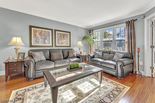 living room featuring crown molding, light wood-style flooring, and baseboards