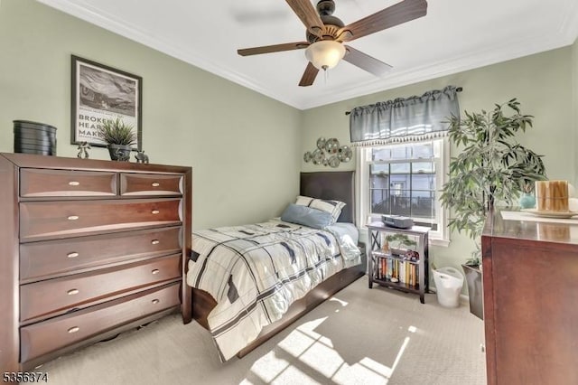 bedroom featuring light carpet, ornamental molding, and ceiling fan