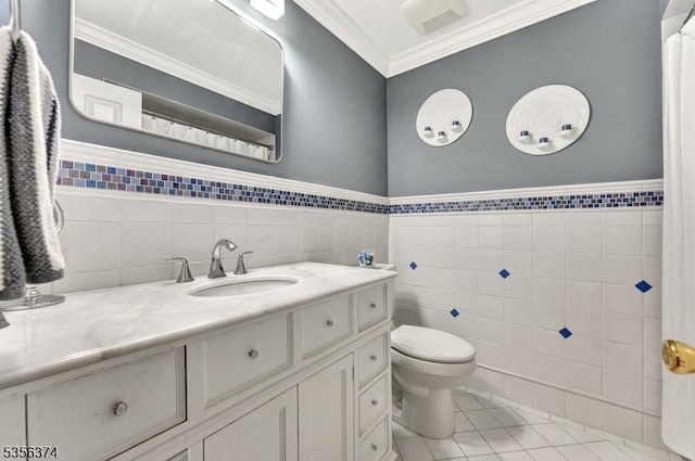 bathroom featuring tile walls, ornamental molding, tile patterned floors, vanity, and toilet
