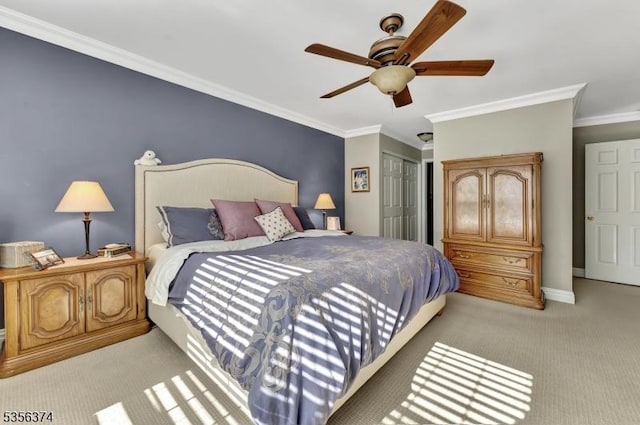 bedroom featuring light carpet, ornamental molding, a closet, a ceiling fan, and baseboards