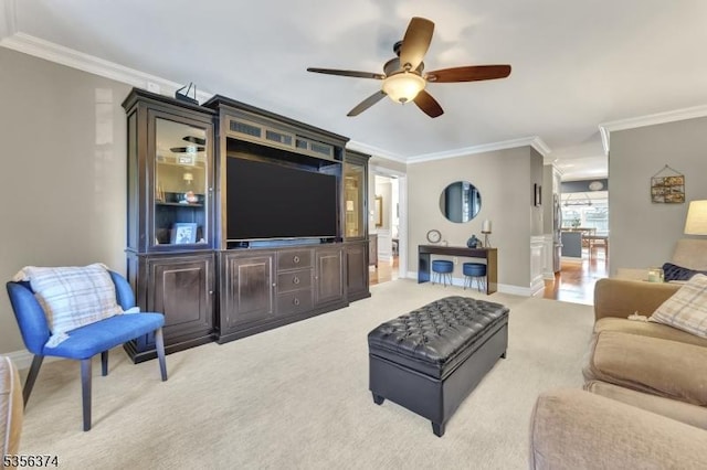 living area with crown molding, light carpet, ceiling fan, and baseboards