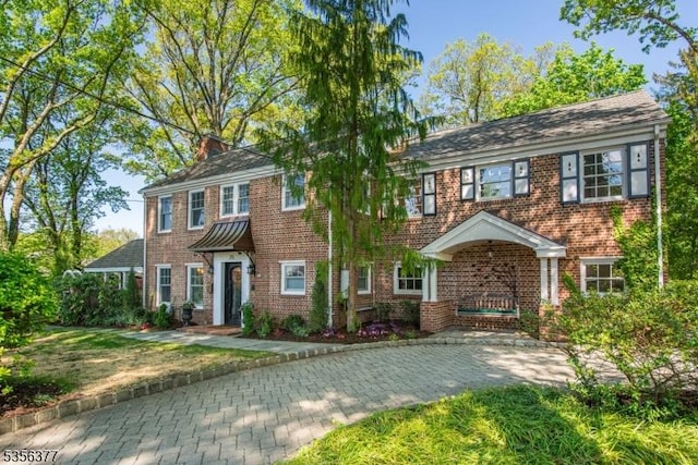colonial-style house featuring brick siding