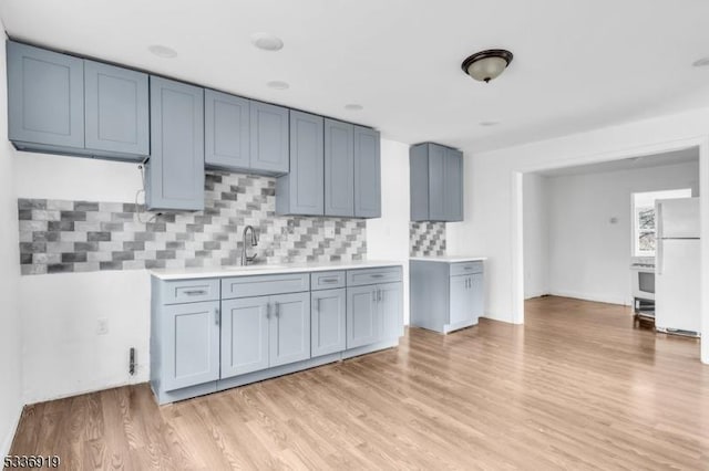 797 Passaic Ave, West Caldwell Twp, NJ 07006 - kitchen featuring freestanding refrigerator, light wood finished floors, backsplash, light countertops, and a sink