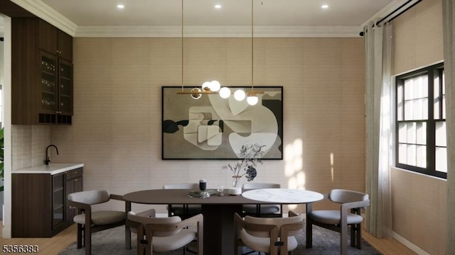 dining space featuring crown molding, light wood-style floors, and baseboards
