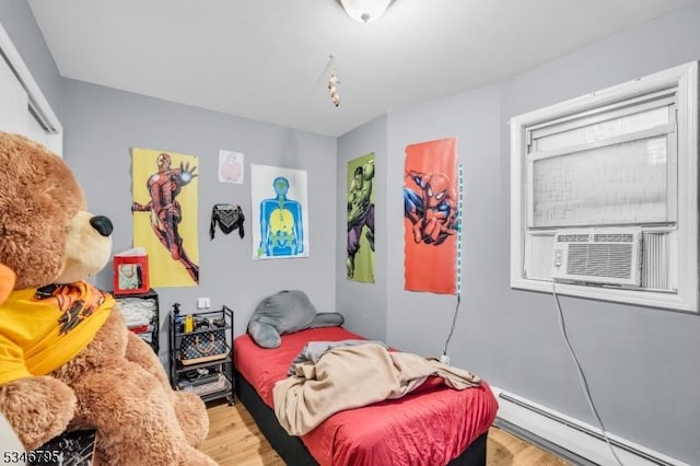 bedroom with a baseboard heating unit, wood finished floors, and cooling unit