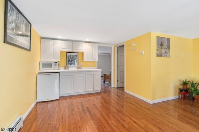 75 Wolfs Corner Rd, Green Twp, NJ 07860 - kitchen featuring white microwave, baseboard heating, dishwasher, light wood-type flooring, and white cabinetry