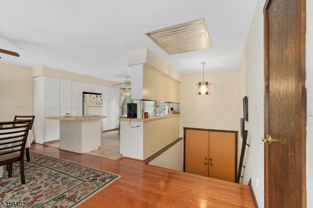 87 Ivy Ln, Bridgewater Twp, NJ 08807 - kitchen with a ceiling fan, freestanding refrigerator, light wood finished floors, and a peninsula