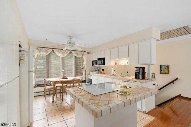 87 Ivy Ln, Bridgewater Twp, NJ 08807 - kitchen with tile counters, white appliances, a baseboard heating unit, a ceiling fan, and white cabinetry