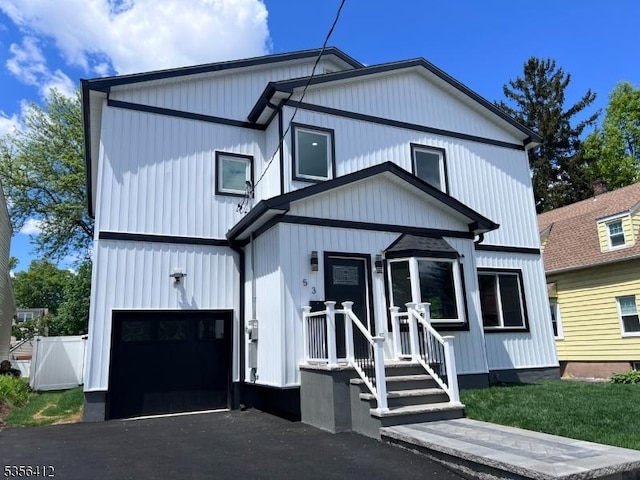 modern farmhouse with a garage, driveway, and fence