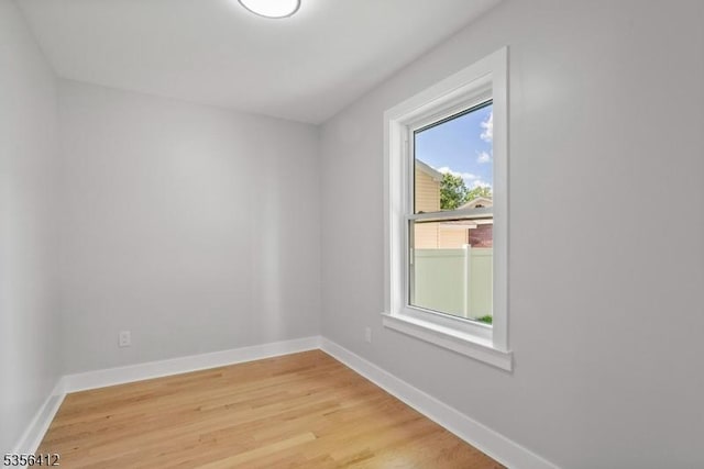 spare room featuring baseboards and light wood finished floors