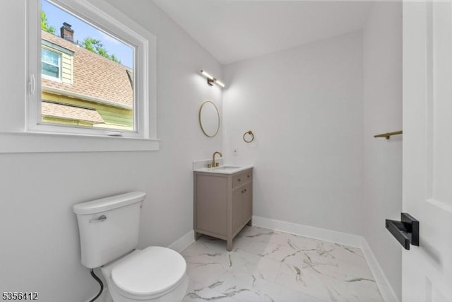 half bath with marble finish flooring, baseboards, vanity, and toilet