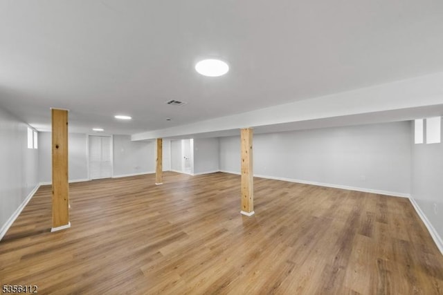 finished below grade area with baseboards and wood finished floors