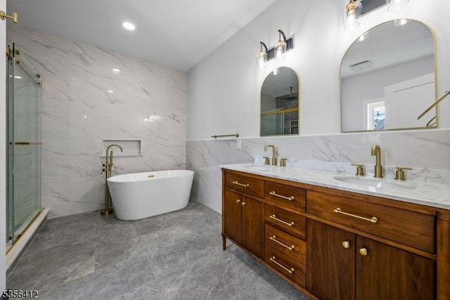 bathroom with tile walls, a marble finish shower, double vanity, a freestanding bath, and marble finish flooring