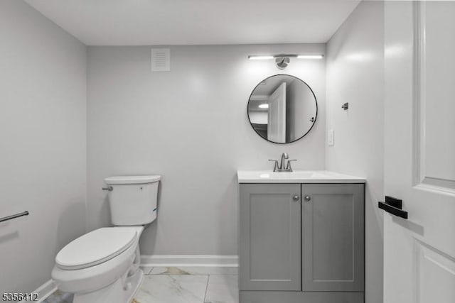 bathroom featuring marble finish floors, vanity, toilet, and baseboards