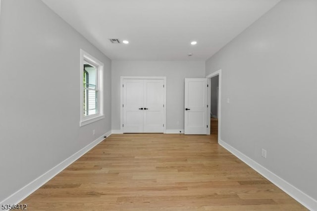 unfurnished bedroom featuring recessed lighting, light wood-style flooring, baseboards, and a closet