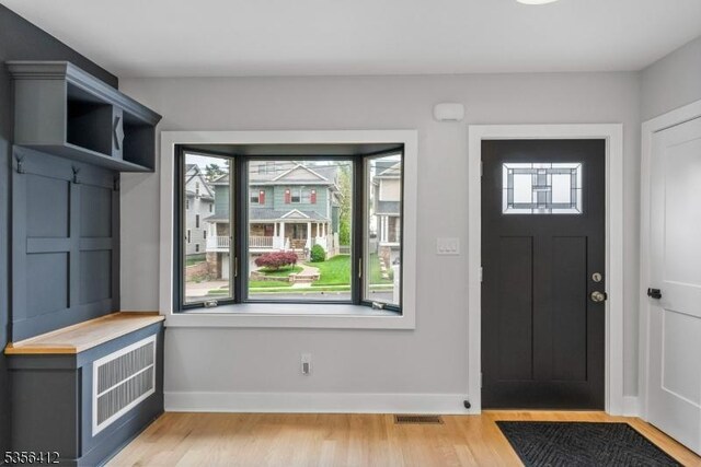 entryway with light wood-style flooring and baseboards