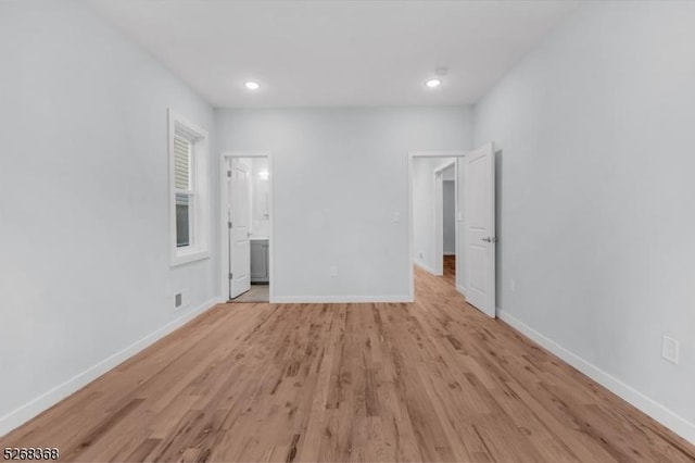 unfurnished bedroom with light wood finished floors, baseboards, recessed lighting, and connected bathroom