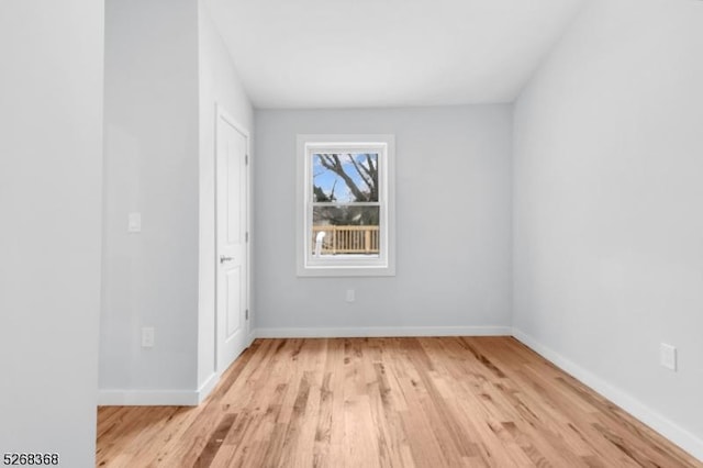 spare room featuring light wood finished floors and baseboards