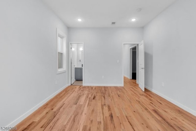 unfurnished bedroom with light wood-style flooring, baseboards, recessed lighting, and ensuite bathroom