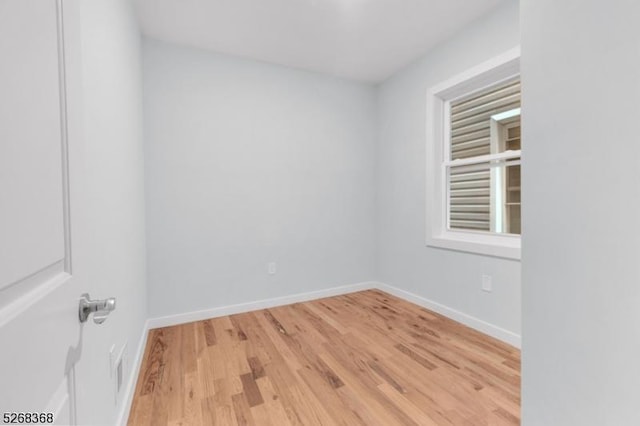 empty room with light wood finished floors and baseboards