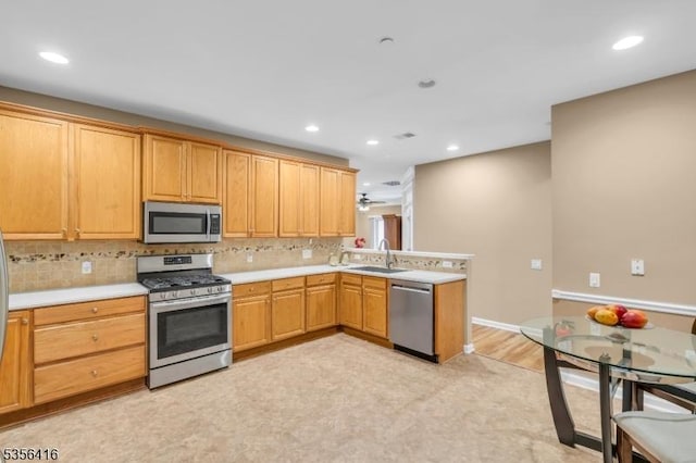 1111 Conrad Way, Franklin Twp, NJ 08873 - kitchen with appliances with stainless steel finishes, a peninsula, light countertops, a sink, and backsplash