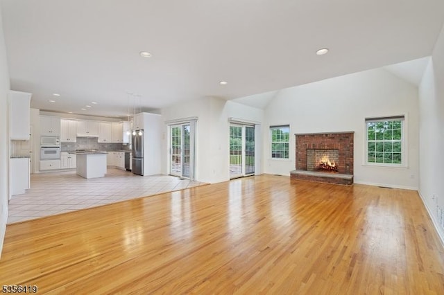 1 Joss Way, Long Hill Twp, NJ 07946 - unfurnished living room with plenty of natural light, light wood-style floors, recessed lighting, a fireplace, and vaulted ceiling