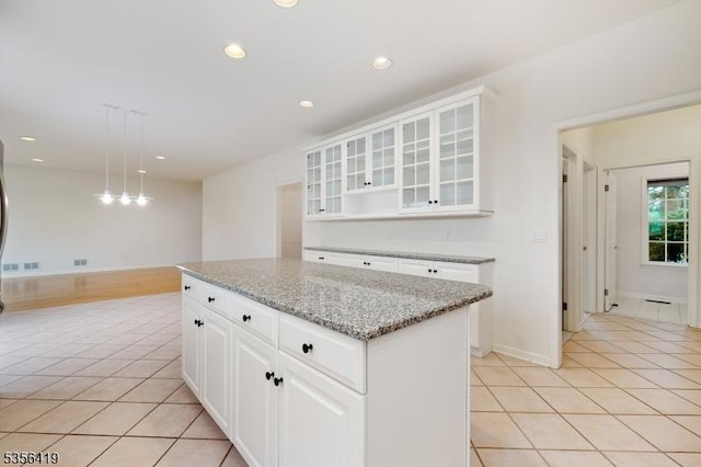 1 Joss Way, Long Hill Twp, NJ 07946 - kitchen with light tile patterned floors, a kitchen island, light stone counters, recessed lighting, and glass insert cabinets