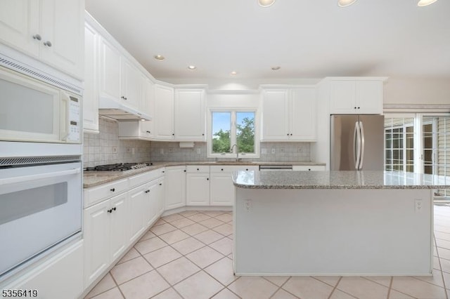 1 Joss Way, Long Hill Twp, NJ 07946 - kitchen featuring stainless steel appliances, decorative backsplash, a kitchen island, white cabinetry, and light stone counters