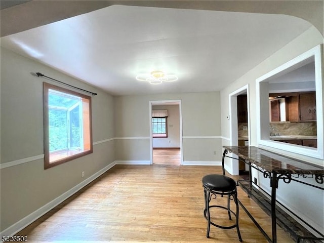 dining area featuring light wood-style flooring and baseboards