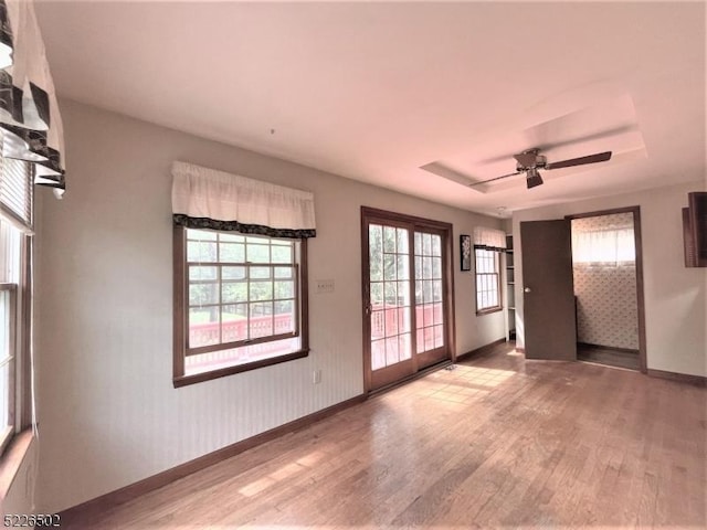 spare room with wood finished floors, baseboards, and a ceiling fan