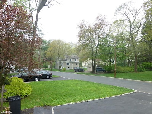 view of asphalt street featuring curbs