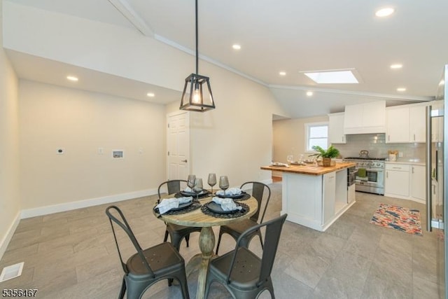 dining area featuring vaulted ceiling, recessed lighting, baseboards, a skylight, and ornamental molding