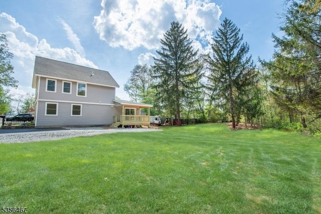 back of property featuring a yard and a wooden deck