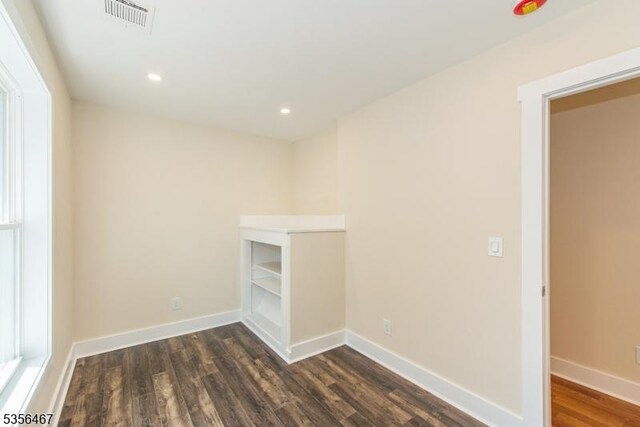 empty room featuring dark wood-style floors, baseboards, and recessed lighting