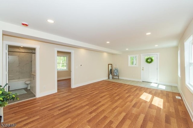 unfurnished living room with light wood-type flooring, baseboards, and recessed lighting