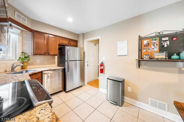 3522 Richmond Ct, Hillsborough Twp, NJ 08844 - kitchen with stainless steel appliances, a sink, brown cabinetry, light tile patterned flooring, and baseboards
