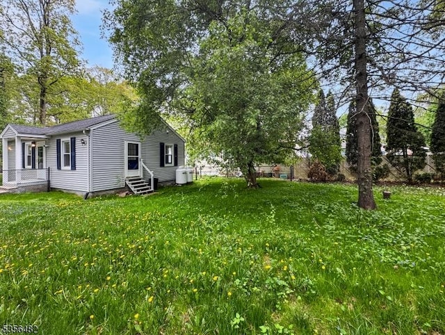 view of green lawn with entry steps