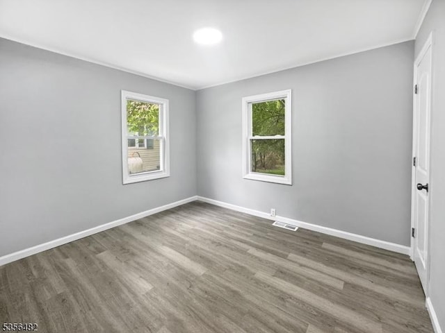 unfurnished room with baseboards, wood finished floors, and ornamental molding