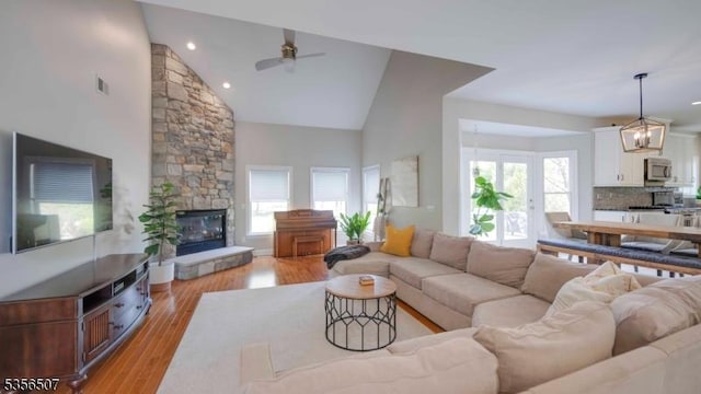 1 Dewing Ct, Raritan Twp, NJ 08551 - living room with ceiling fan, high vaulted ceiling, light wood-type flooring, a stone fireplace, and a chandelier