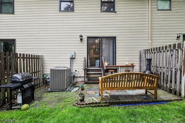 rear view of house featuring central air condition unit, fence, and entry steps