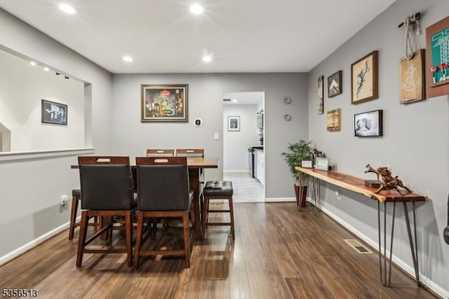 dining room featuring recessed lighting, dark wood finished floors, and baseboards