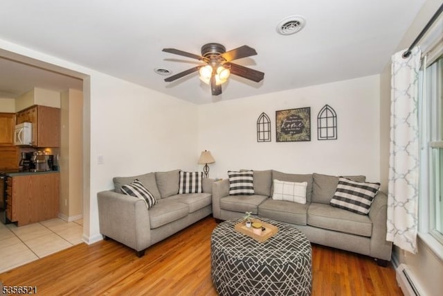 19 Esther Dr, Vernon Twp, NJ 07422 - living area featuring a baseboard radiator, ceiling fan, light wood-style floors, and baseboards