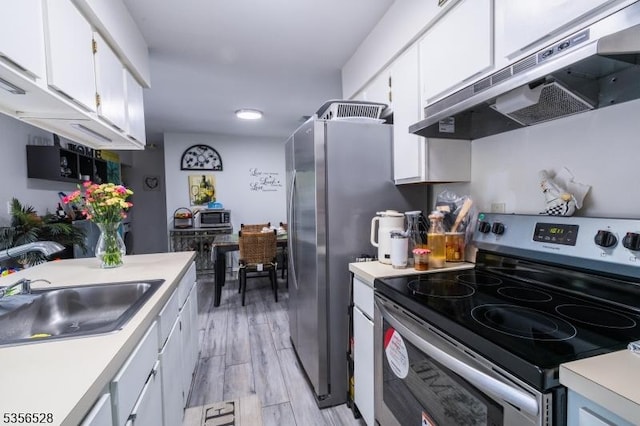 kitchen with under cabinet range hood, stainless steel appliances, a sink, and light countertops