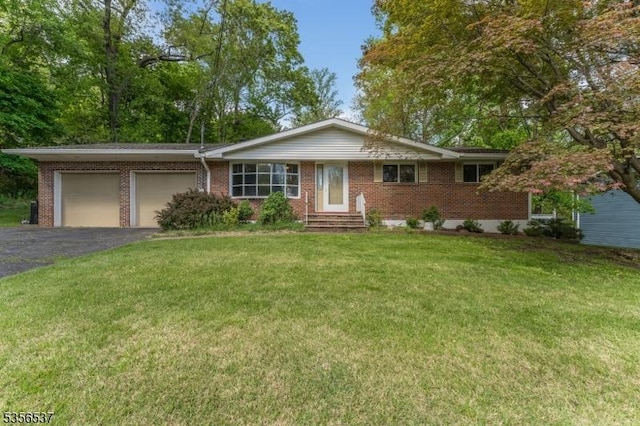 ranch-style home with an attached garage, brick siding, asphalt driveway, and a front lawn