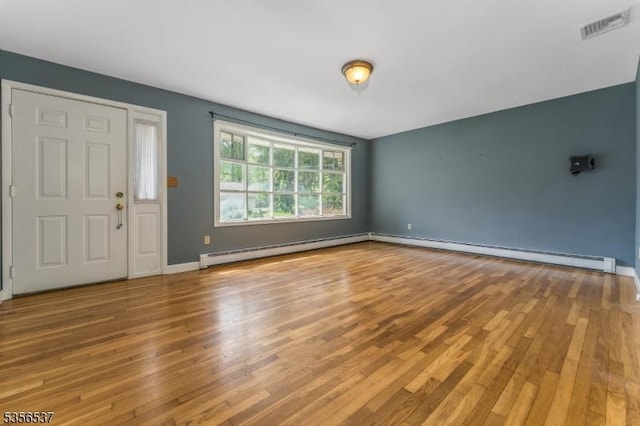 entrance foyer with a baseboard radiator, wood finished floors, and baseboards
