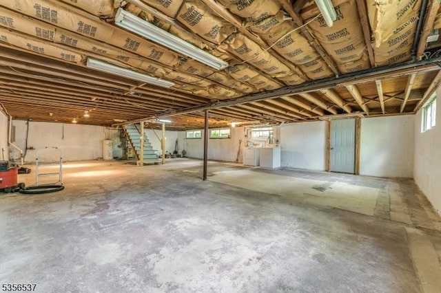 below grade area with washing machine and dryer, water heater, and stairs