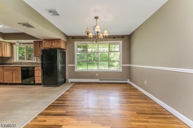 kitchen with black appliances, light wood-style flooring, a chandelier, and healthy amount of natural light