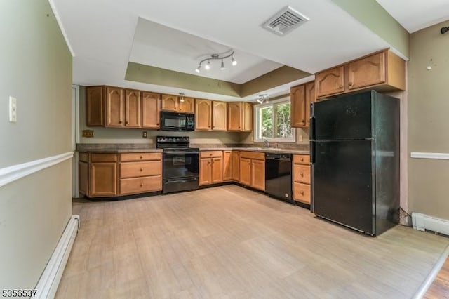 kitchen with black appliances, light wood-type flooring, a raised ceiling, a baseboard heating unit, and a sink