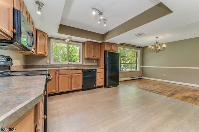kitchen featuring black appliances, a raised ceiling, a sink, a baseboard heating unit, and a chandelier